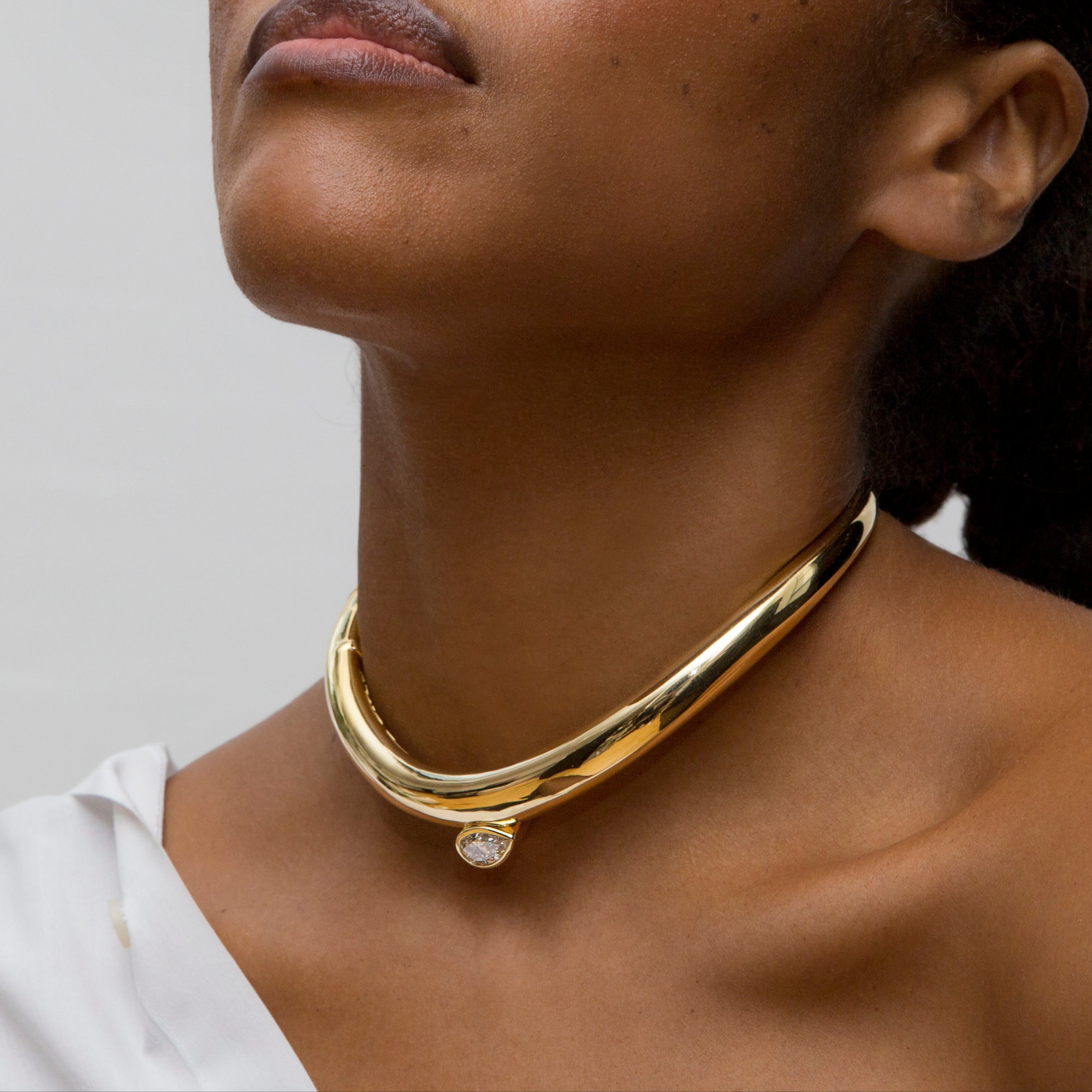 Person wearing 14k yellow gold and pear-cut diamond choker