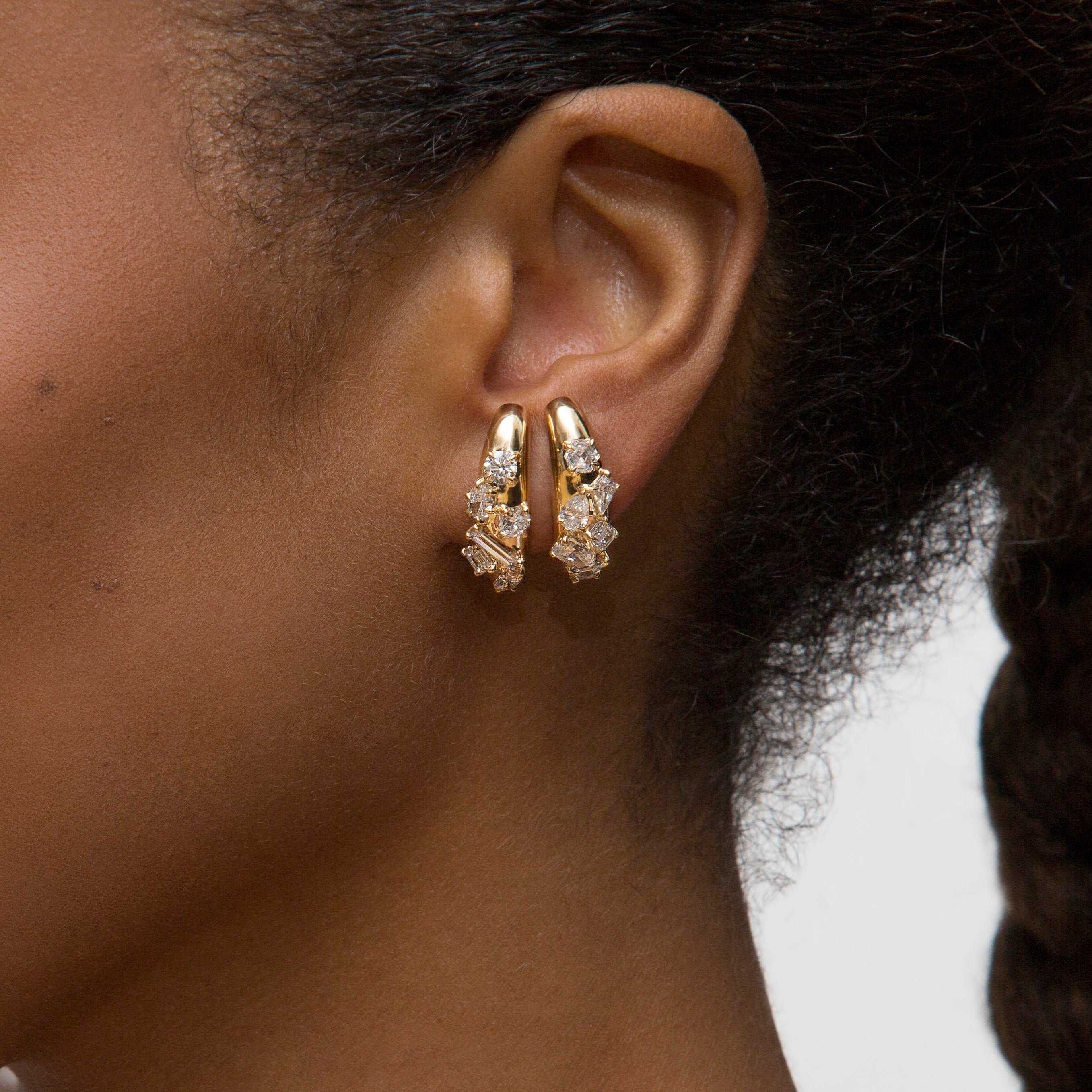 Close-up person wearing yellow gold Azadi Bombe Cluster Ear Arcs