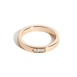 A gold band ring with diamonds set in a specific pattern to represent letters in Morse code.