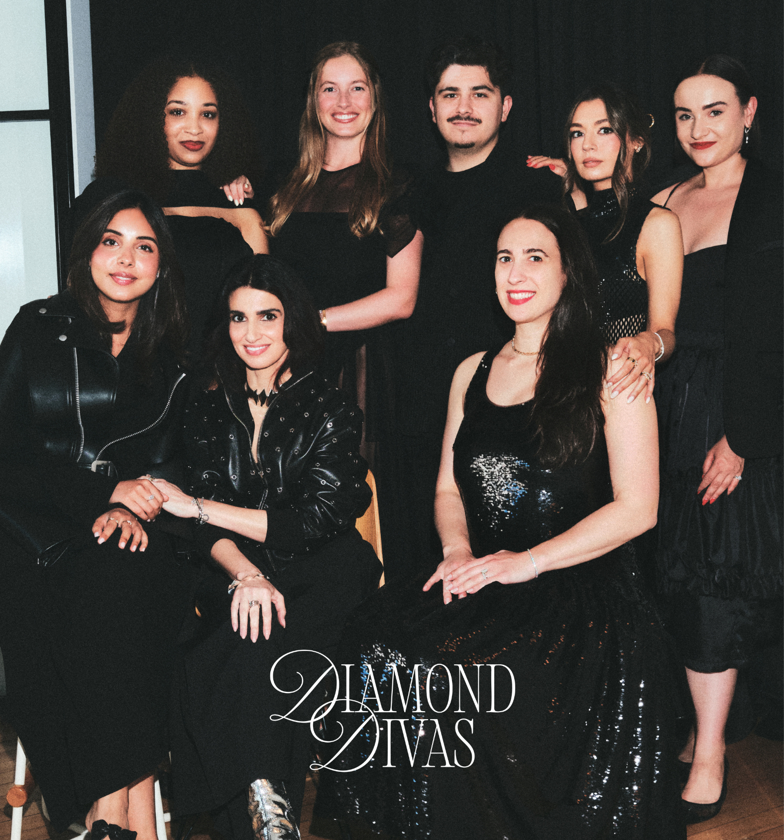 A group of seven women and one man posing together in elegant black evening wear, with the text 'Diamond Divas' overlaid at the bottom on a dark background.