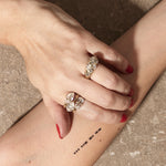 stacked engagement rings on hand with textured background