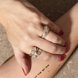 stacked engagement rings on hand with textured background