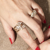 stacked engagement rings on hand with textured background