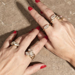 stacked engagement rings on hand with textured background