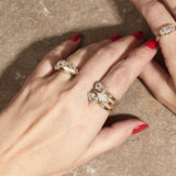 stacked engagement rings on hand with textured background