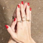 stacked engagement rings on hand with textured background