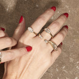 stacked engagement rings on hand with textured background