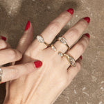 stacked engagement rings on hand with textured background