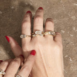 stacked engagement rings on hand with textured background