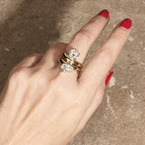 cloud offset pear ring paired with cloud round ring on hand with textured background