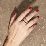 cloud offset emerald ring paired with cloud wedding band on hand with textured background