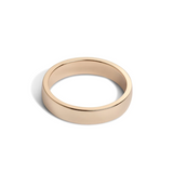 A 5mm wide, low-dome gold band ring with a high polish finish.