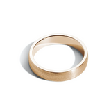A 5mm wide, low-dome gold band ring with a horizontal satin finish.