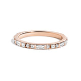 A white diamond demi band ring with rotating diamond baguettes and princess-cut stones set in a gold band.