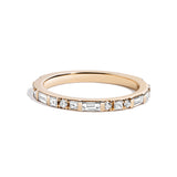 A white diamond demi band ring with rotating diamond baguettes and princess-cut stones set in a gold band.