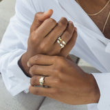 closeup of model's hands with gold bands