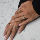 gold rings on model's hand with white and gray background