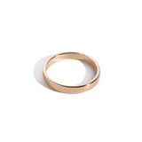 A gold-colored 3mm vertical hammered band ring on a white background.
