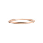 simple thin rose gold metal band on white background