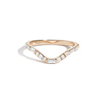 A curved yellow gold band ring with a central row of set white diamonds, surrounded by smaller round white diamonds.