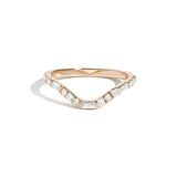 A curved yellow gold band ring with a central row of set white diamonds, surrounded by smaller round white diamonds.